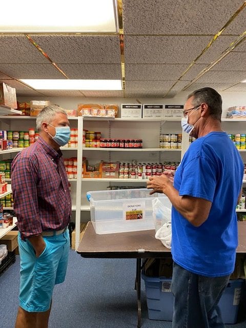 Senator Kevin Witkos (L) speaks to Friendly Hands Food Bank Board President Danny Harnett (R) in a store room at about their current donation needs.